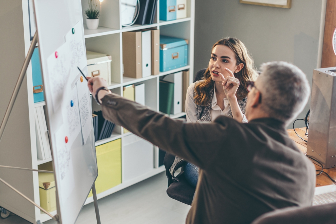 A business coach mentoring and guiding a female business professional.