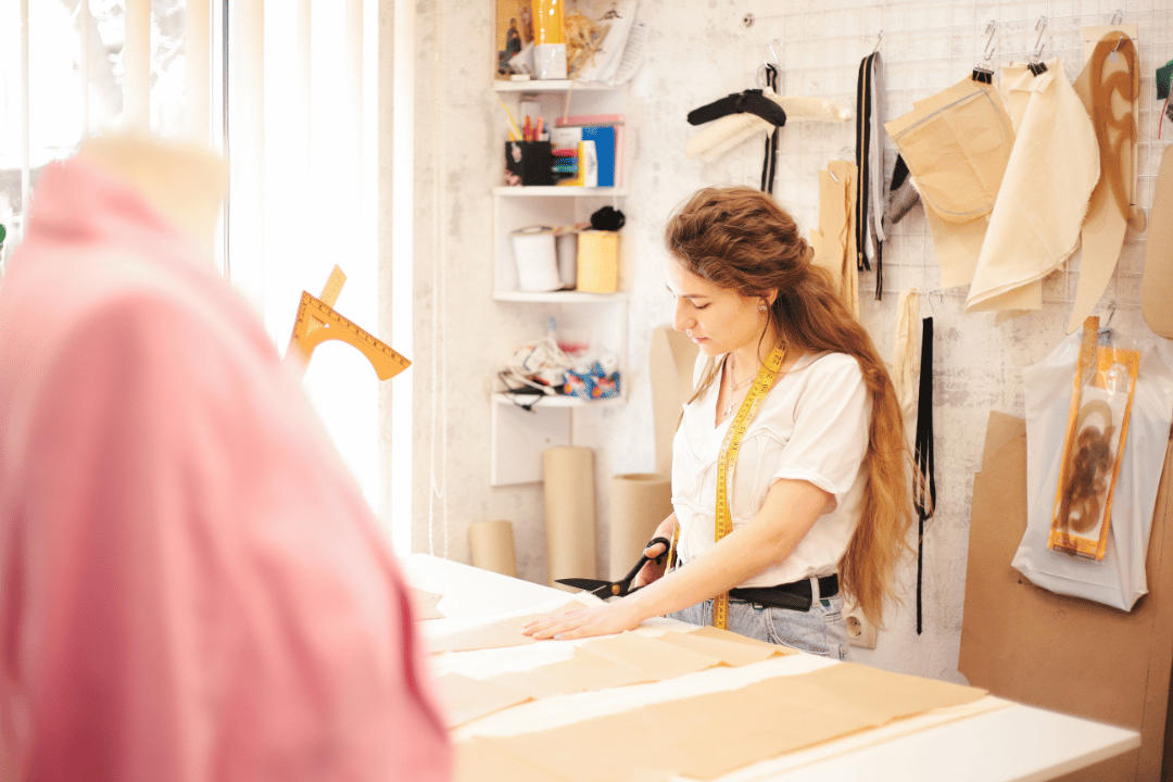 Entrepreneur dressmaker measuring fabric to create a new dress